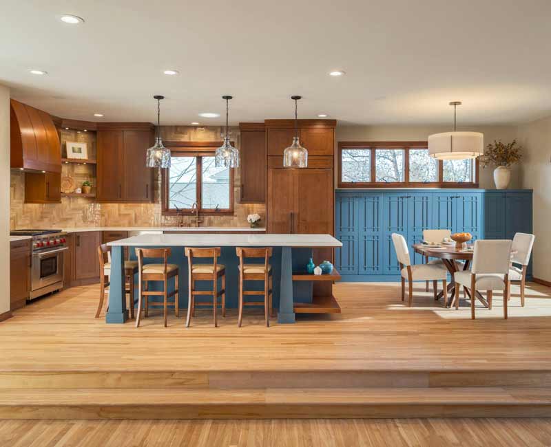 This whole-house remodel features a prairie-style kitchen adorned with custom cabinetry by DHDK, a primary suite with custom alder armoire, and bathroom with iridescent blue-green tiles.