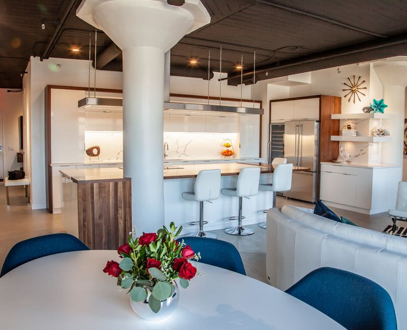 White and stainless steel dominate in this minimalist condo showcasing contemporary artwork. 