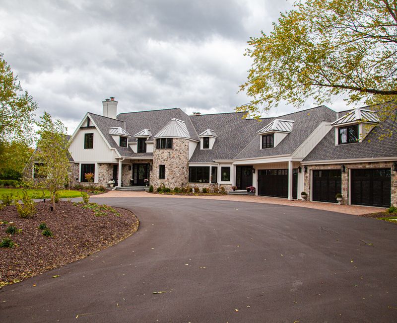 This country home has a rustic chic style with rough-hewn exposed wood beams, hand-painted terra cotta tiles, and a stone turret.