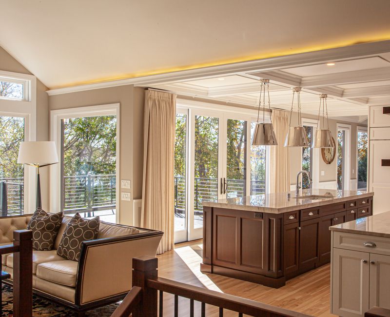 This lakeside brick home has vaulted and coffered ceilings, twin picture windows on either side of a fireplace, hardwood floors, two second-story decks, and a finished basement. 